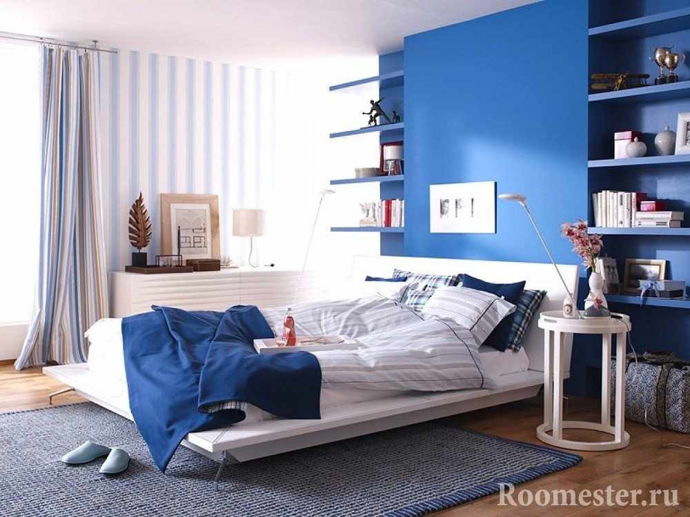 Синяя стена в спальне в сочетании с обоями в полоску