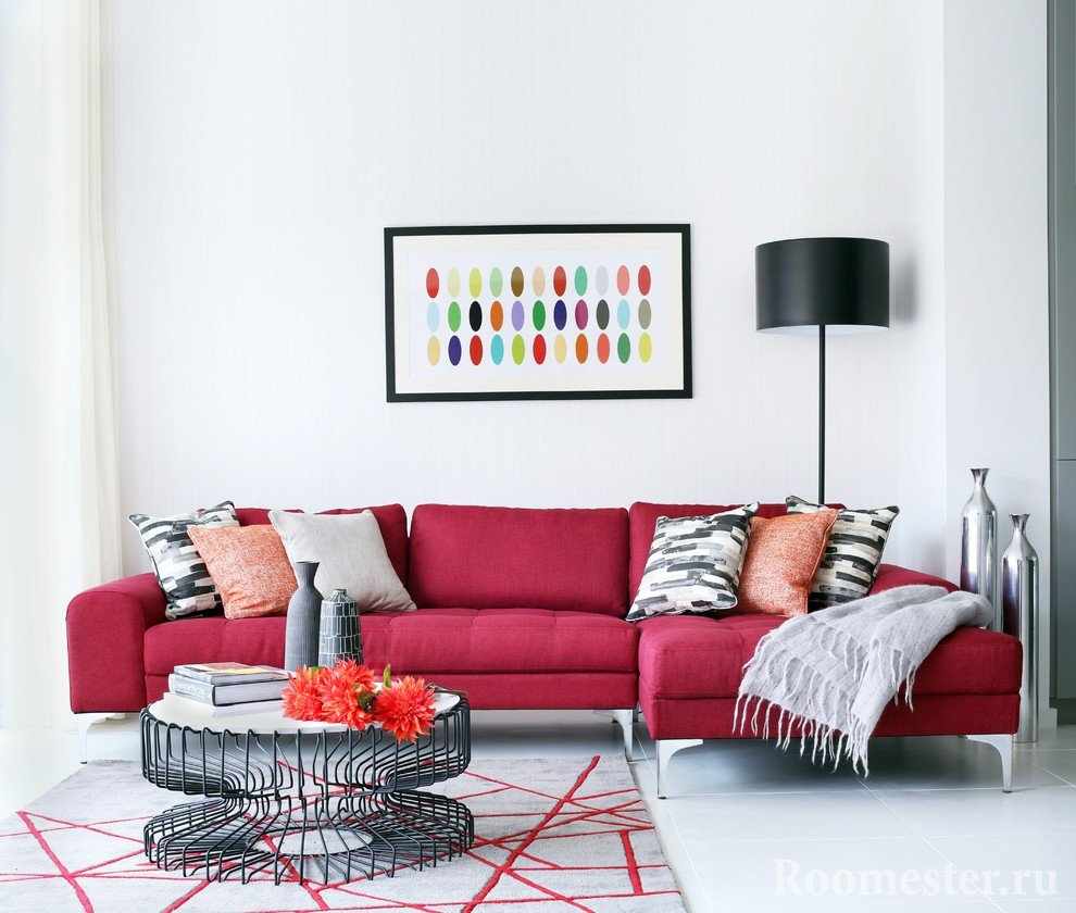 Бардовый диван в комнате с белыми стенами