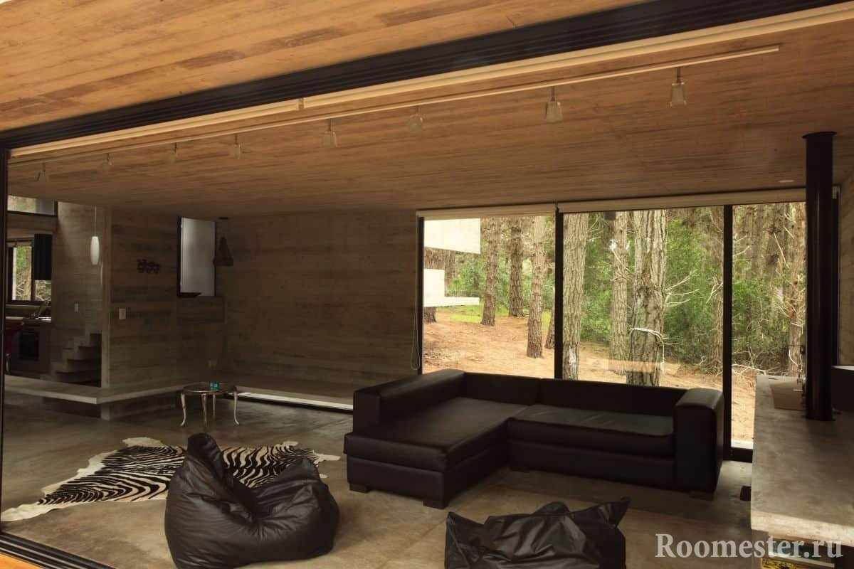 Гостиная с отделкой под дерево в деревянном доме с панорамным окном