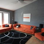 Оранжевая мебель в серой комнате
