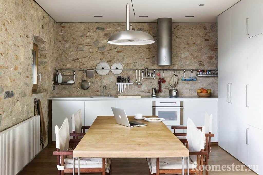 Кухня с бетонными стенами и большим шкафом с обеденной зоной