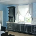 Сочетание голубых стен и черной мебели на кухне