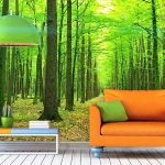 Оранжевый диван на зеленом фоне леса