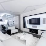 Белый угловой диван и столик напротив телевизора