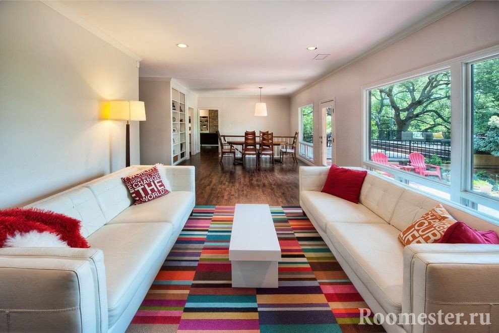 Гостиная с белыми диванами и цветным ковром
