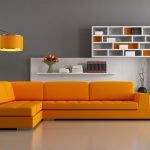 Угловой оранжевый диван в сером интерьере