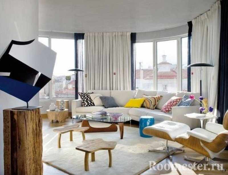 Полукруглая комната с белой и деревянной мебелью